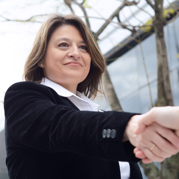 Close up of business woman hand shaking for making a deal. Outdoors.